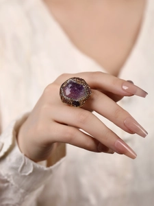 Detailed view of irregular purple raw amethyst ring with gold plating and zircons