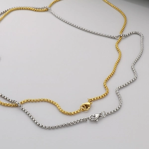 Close-up of gold and silver stainless steel box chain necklaces with lobster clasps