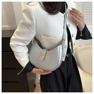 Détail du sac demi-lune gris clair avec bandoulière réglable et boucle carrée dorée