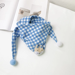 Blue and white checkered kids scarf with fox plush and blue pom-poms on a white fabric