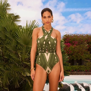 Detail of olive green geometric halter swimsuit with crossover neck at a resort pool