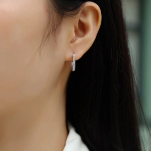 Close-up of minimalist silver hoop earrings with shimmering double-row pavé crystals
