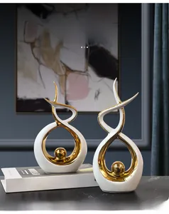Close-up of modern abstract ceramic sculptures in white and gold for home decor