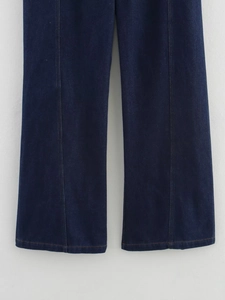 Détail d'un pantalon en jean bleu foncé avec couture verticale et ourlet bien fini