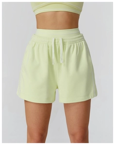 Dettaglio dei pantaloncini sportivi verde chiaro con coulisse e strisce laterali bianche