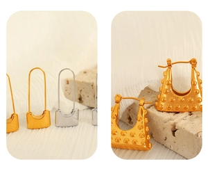 Macro shot of gold and silver padlock earrings and golden handbag shaped hoops
