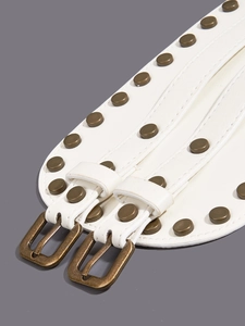 Detail of white leather corset belt featuring vintage bronze rivets and double pin buckles