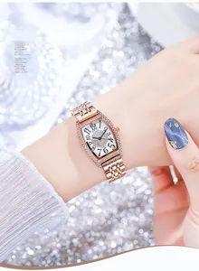 Gros plan d'une montre tonneau en or rose avec cadran serti de cristaux sur paillettes