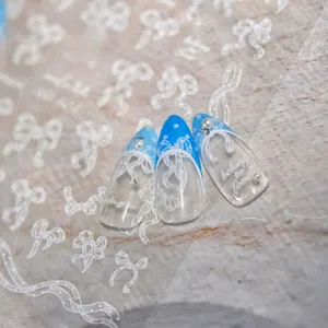 Détail d'autocollants pour ongles papillon en dentelle blanche avec perles sur ongles bleus