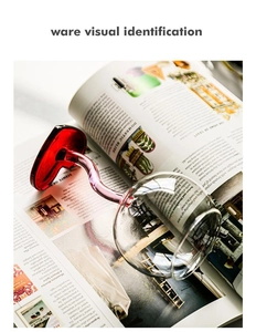 Detailed view of a red heart-shaped glass with a long clear stem on an open magazine