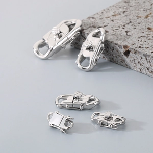 Detailed view of silver stainless steel Cuban clasp connectors on a textured stone base