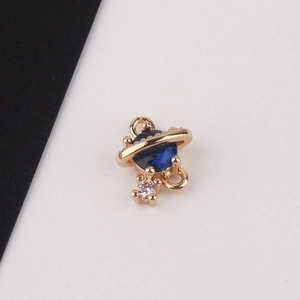 Macro shot of gold-plated planet charm with blue zircon and white crystal detail