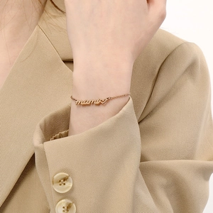 Detail of rose gold mama bracelet with heart charm worn on wrist for Mother's Day gift
