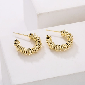 14K gold plated geometric C-shape earrings with unique textured scale pattern on white podium