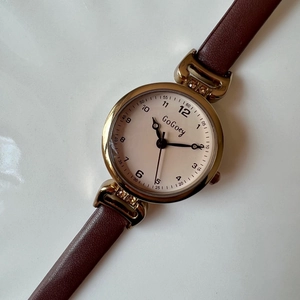 Detail of a GoGoey women's watch with brown faux leather strap and golden case