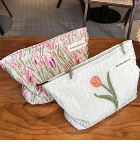 Detail of tulip canvas makeup bags with pleated texture and A GOGO ORIGINAL brand labels