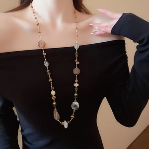 Dettaglio della collana lunga con perle di agata marrone e marmo su una modella