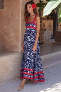 Detailed view of dark blue spotted maxi dress with vibrant red wavy trim and ethnic patterns