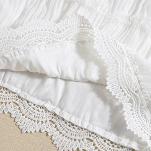 Detailed macro view of white floral lace texture and pleated chiffon fabric craftsmanship