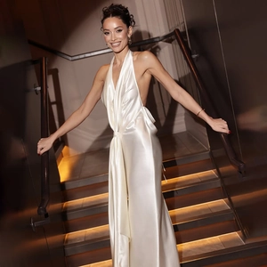 Détail d'une robe de soirée dos nu en satin blanc avec licou et fente latérale haute