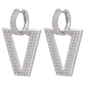 Macro shot of silver V-shaped earrings fully encrusted with white zircon stones