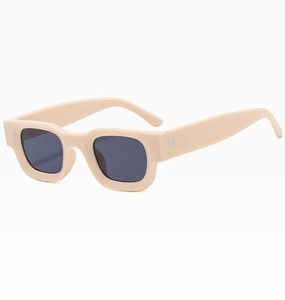 Detail view of the wide cream rectangle frame and dark gray lenses on retro sunglasses