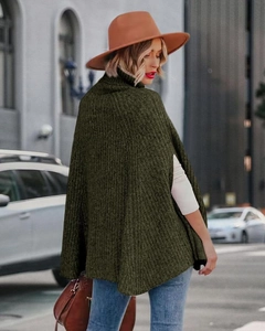 Dettaglio di un poncho in maglia grossa verde oliva a collo alto per la moda autunno-inverno