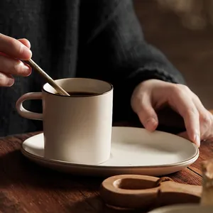 Handcrafted Banko-yaki ceramic coffee cup and saucer set in matte beige with brown rim