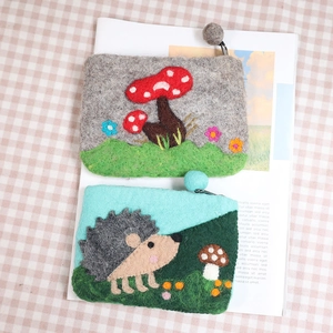 Cute wool felt coin purses with hedgehog and mushroom designs, featuring pom-pom zippers