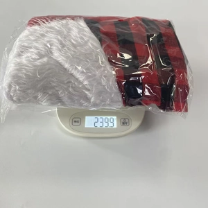 Mesure du poids de 239,9g d'un sac cadeau de Noël à motif écossais emballé