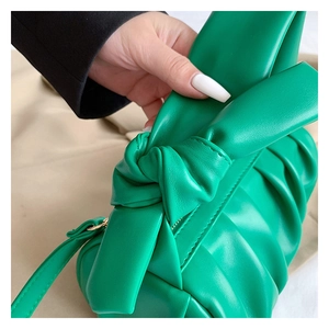 Detailed view of the green pleated cloud bag featuring a unique knotted handle design