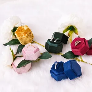 Hexagon velvet jewelry boxes for rings in multiple colors on a plush white background