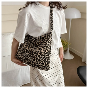 Detail shot of a large leopard print tote bag styled in a modern living room setting