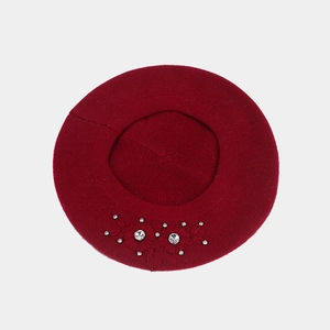 Détail du béret bordeaux avec fleur brodée et décorations en strass étincelants
