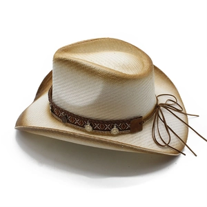Detail of bohemian straw cowboy hat featuring ethnic embroidery and gold coin pendants