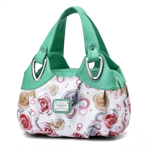 Close-up of mint green leather and floral fabric stitching with silver metal buckle