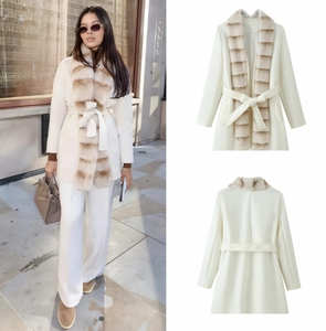 Detail of wool coat with faux fur collar and waist belt in elegant ivory white