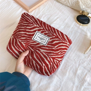 Close-up of red and white zebra pattern canvas pouch with Time to Party label
