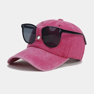 Detail of rose pink washed cotton baseball cap with integrated decorative black sunglasses