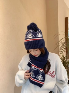 Dettaglio del set cappello e sciarpa in maglia Fair Isle con motivi a fiocco di neve