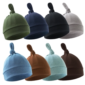 Set of 8 colorful newborn knot hats in soft cotton knit fabric on a white background