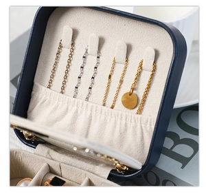 Macro detail of necklace hooks and ring slots in the navy blue jewelry box interior