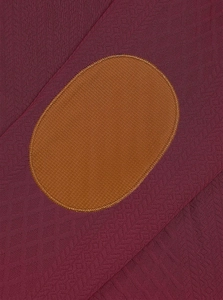 Détail macro du tissu bordeaux tricoté avec empiècement marron et finitions de couture