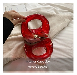 Detail view of red acrylic evening bag showing internal capacity for phone and cosmetics