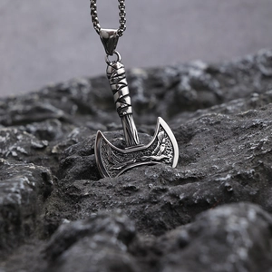 Macro shot of Viking battle axe pendant with eagle engraving on dark rock background
