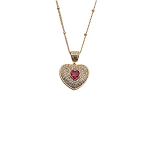 Detailed close-up of heart pendant necklace with red gemstone and pavé crystal setting