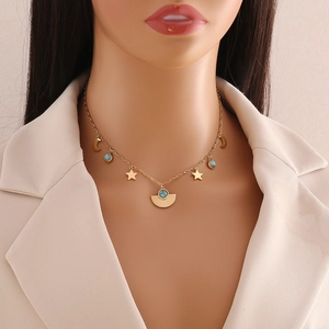 Gold stainless steel necklace with turquoise eyes, star and moon charms on a model