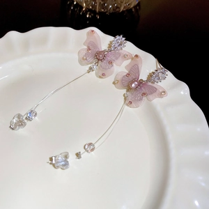 Détail de boucles d'oreilles papillon en tulle lavande avec de longs glands