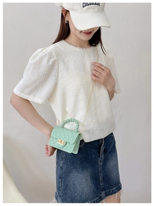 Detail of mint green jelly bag featuring diamond texture and beaded handle decoration