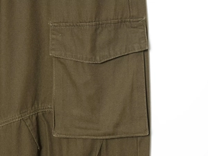 Detail of army green cargo pants featuring a large flap pocket and canvas fabric texture